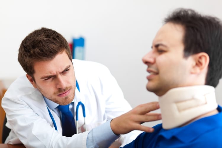 Car accident doctor looking at patients neck in brace