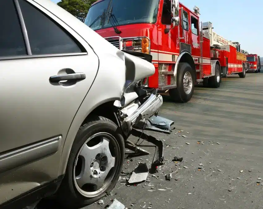 Silver car and red truck in a rear collision glass and debris on roadside