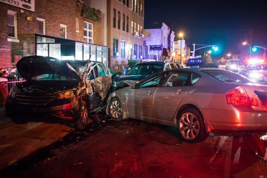 Three car collision at night busy intersection front and sideswipe accident