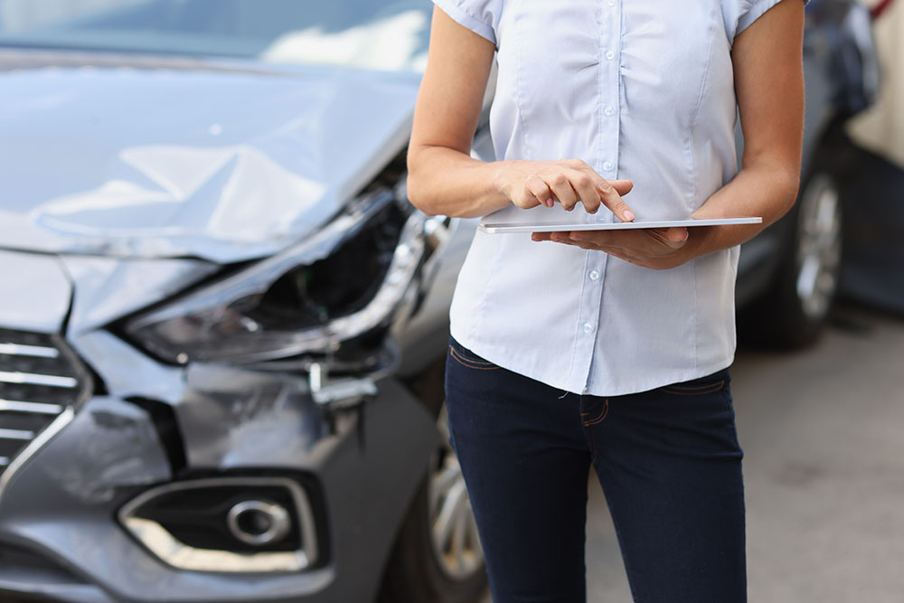 Female loss adjuster inspecting damage for car accident claim in Georgia