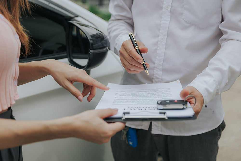 Male and female insurance agents discussing accident report on clipboard