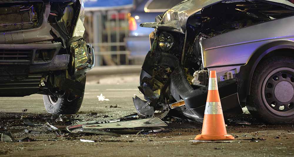 The aftermath of a car crash, with a traffic cone