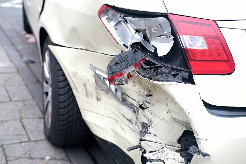 The front end of a vehicle crumpled after a minor accident.