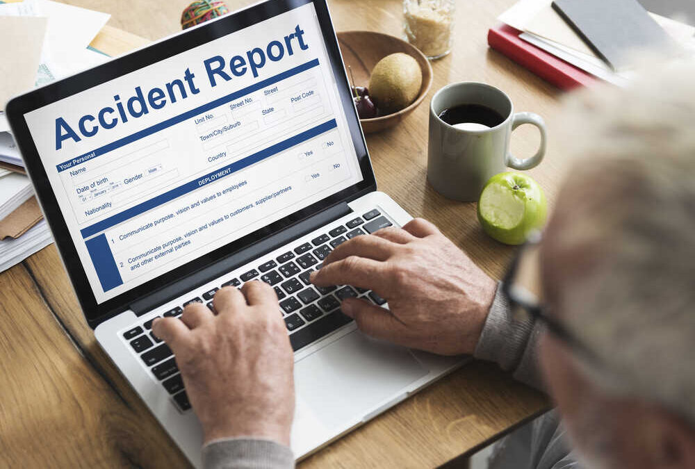 A man uses his laptop to access his accident report